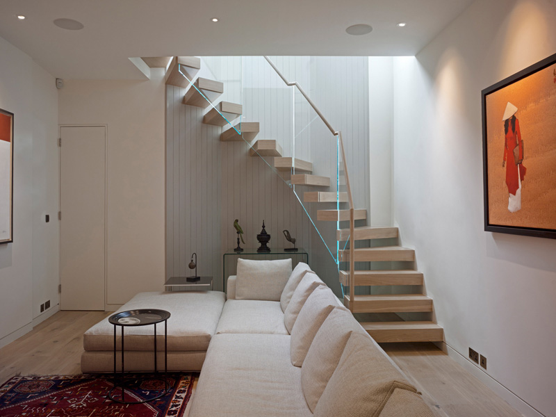 Ladbroke Road, basement tv / cinema room with timber and glass stair with artwork